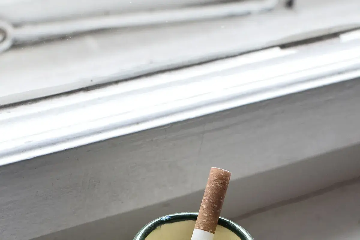 A cigarette in an ashtray indoors, the source of the residue that stays in a house after the smoking stops