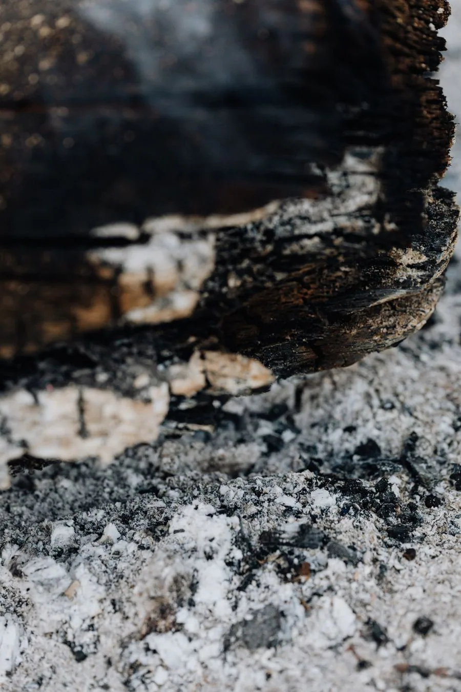 Charred, burnt wood after an electrical fire — burning insulation and plastics leave an oily, corrosive soot behind