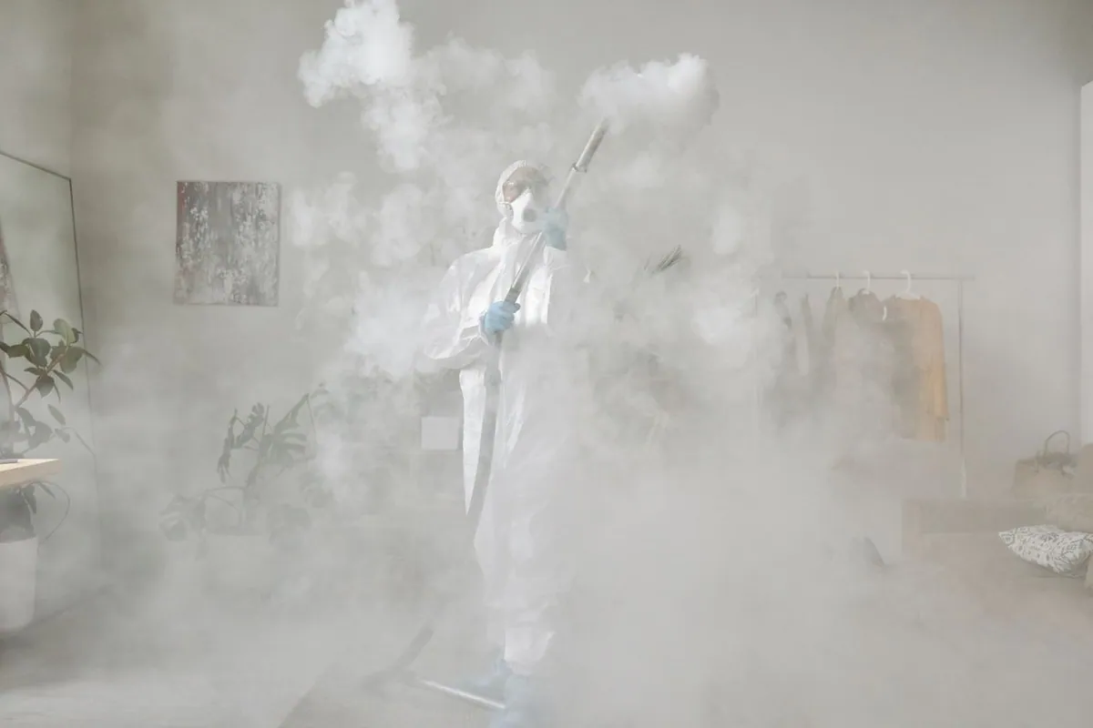 Restoration technician in a respirator preparing to clean soot from masonry and paint
