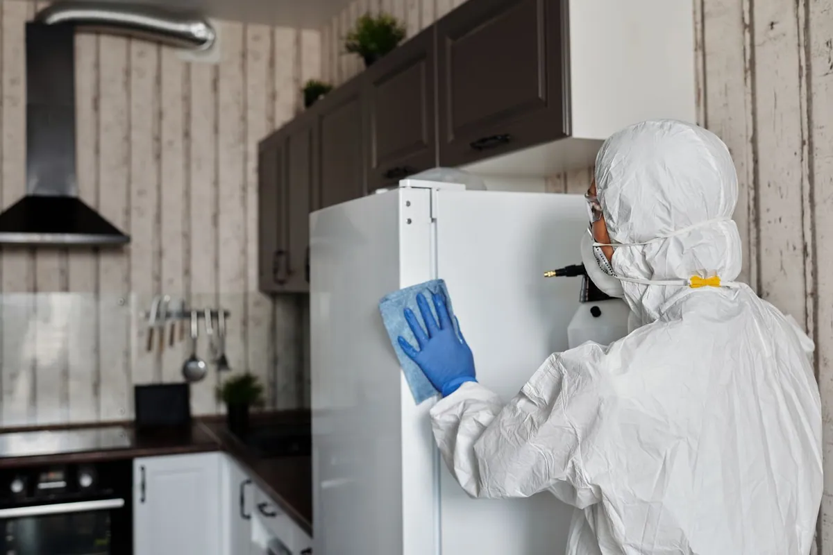 Restoration technician cleaning smoke damage in a kitchen