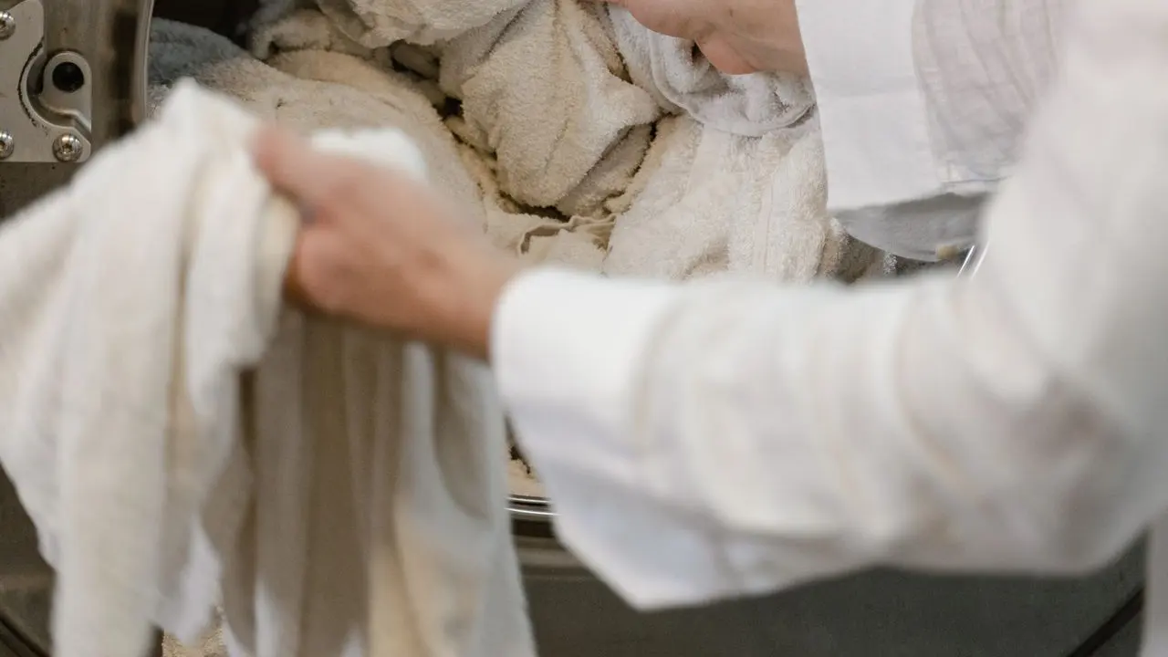Clothes tumbling inside a washing machine drum — washing is only half the job for smoke-affected fabrics